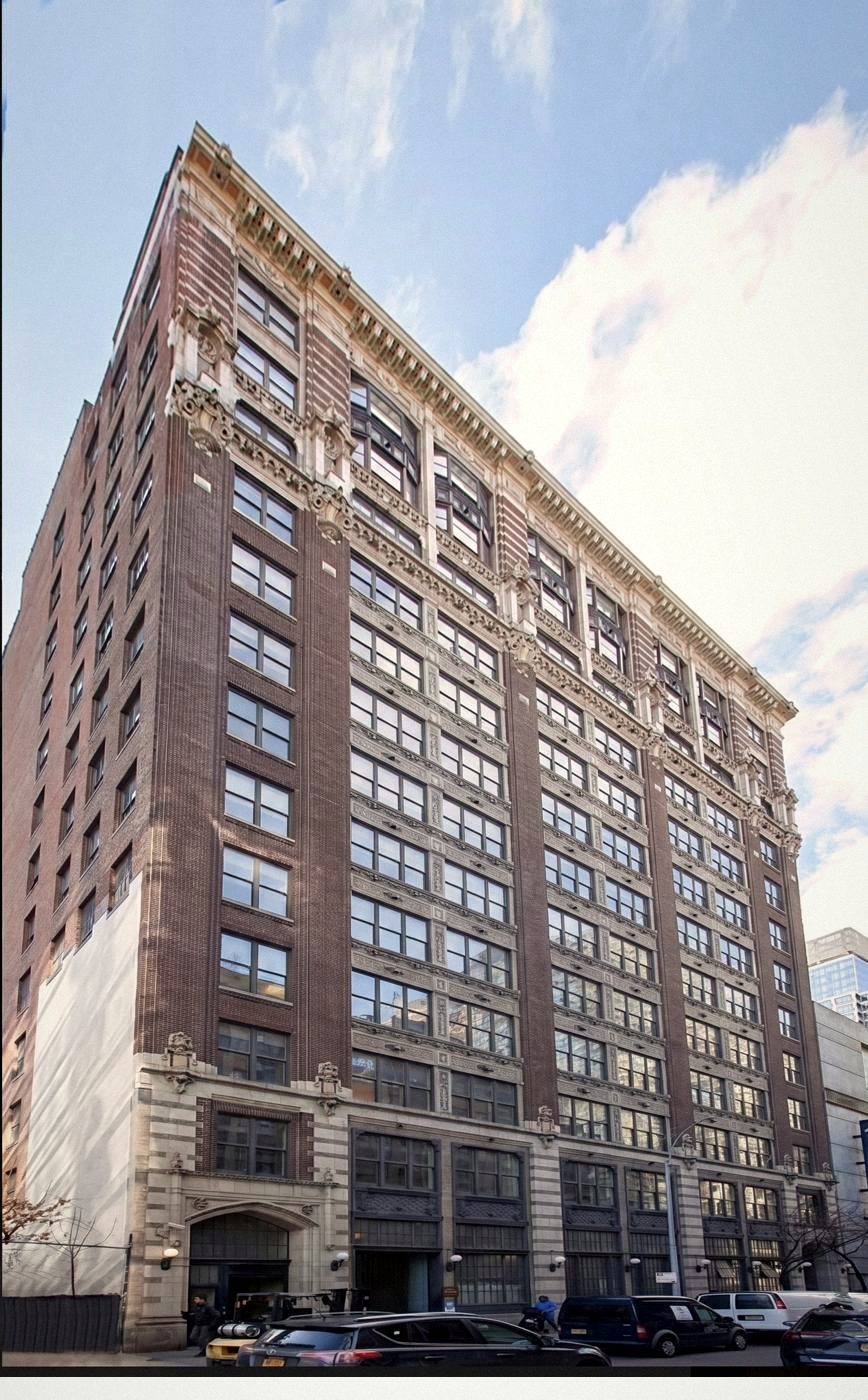 The Glass Farmhouse façade — 13 stories of brick rising into a colored terra cotta crown
