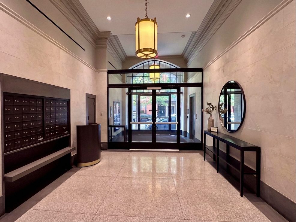 The restored residential lobby, with mailbox wall and a steel-framed glass vestibule